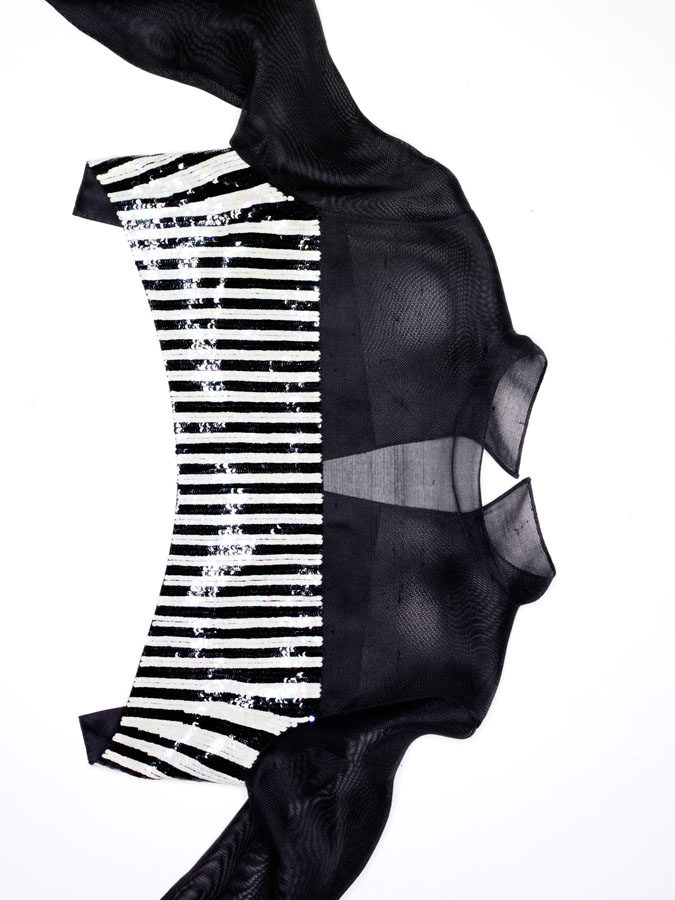 Geoffrey Beene demi-cut over blouse of black gazar and sequined stripes.