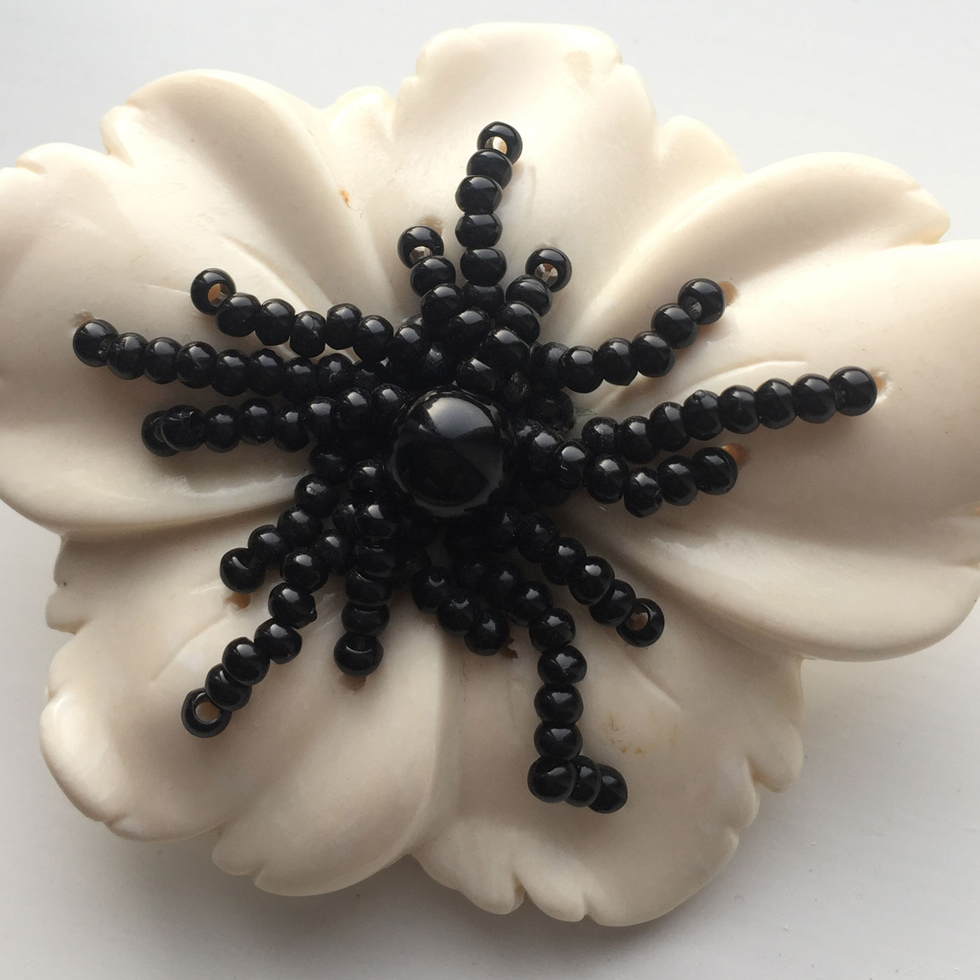 Geoffrey Beene white ceramic brooch strung with jet beading